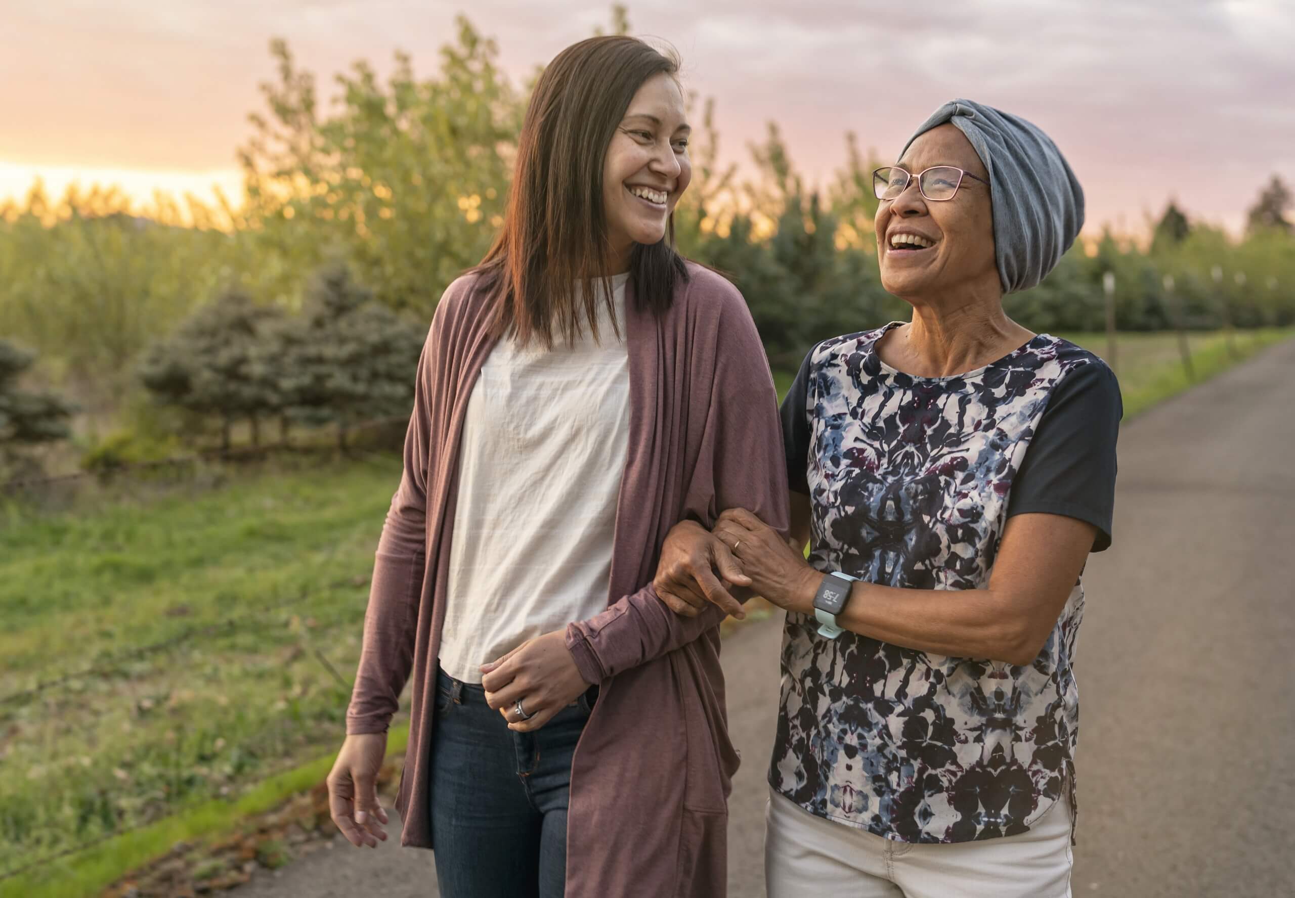 image of a mom and daughter walking arm in arm down a path