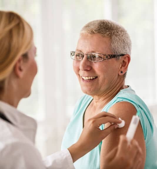 image of doctor giving an older woman her vaccination